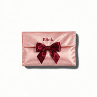 The Satin Pouch®, trousse de toilette en satin rose Blink. fermée par un nœud bordeaux